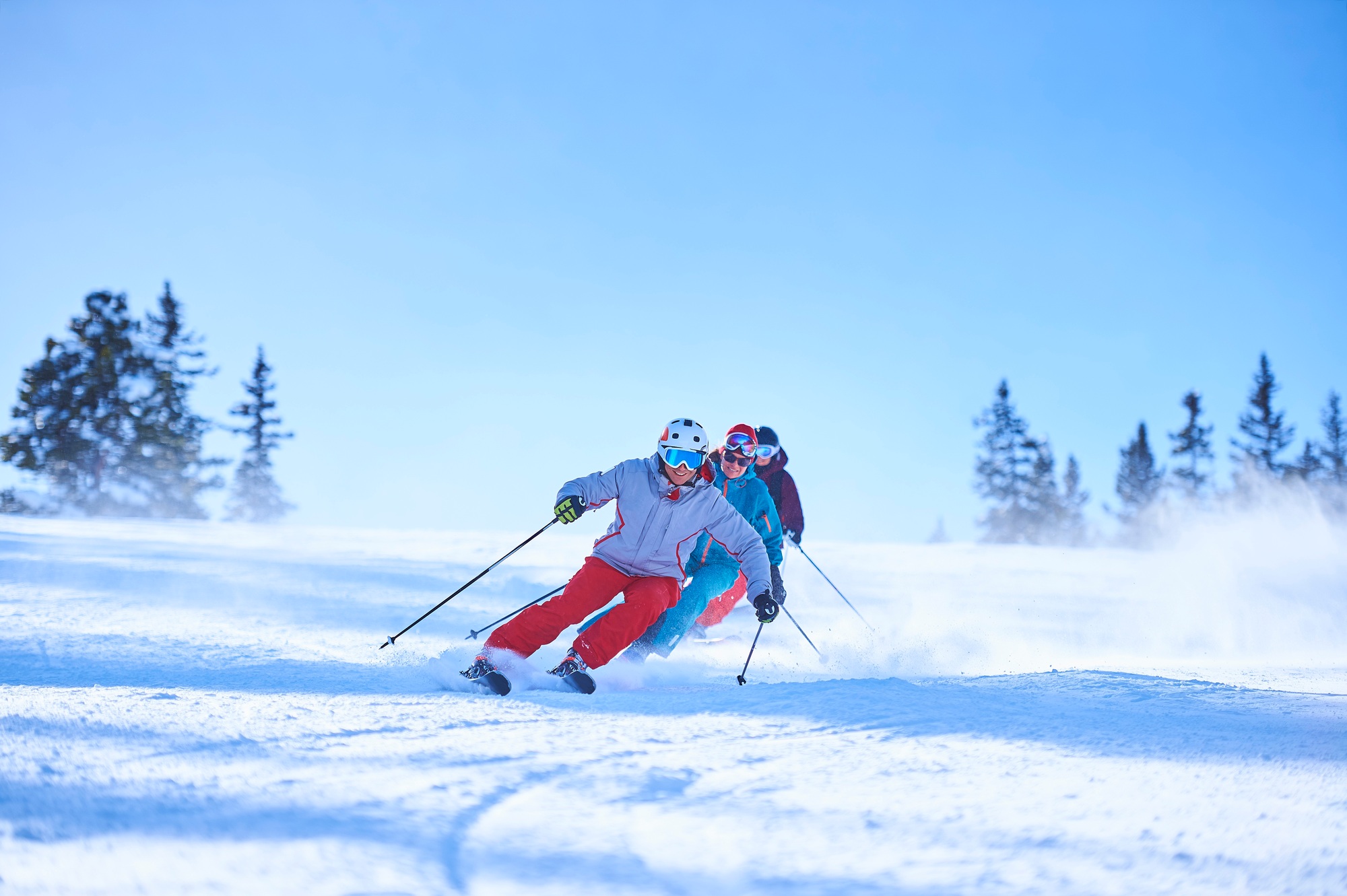Row of male and female skiers skiing down snow covered ski slope, Aspen, Colorado, USA