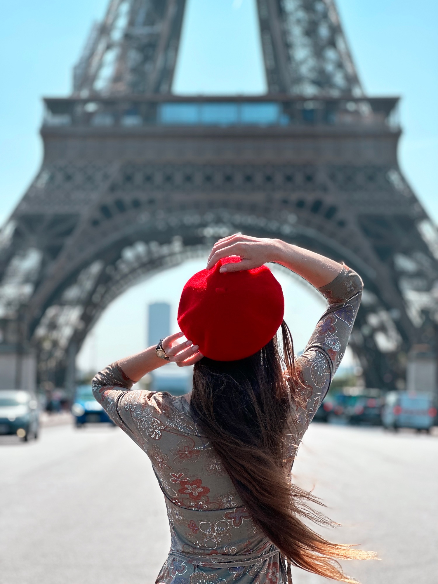 Young Woman With Long Hair Wearing a Red Beret Standing in Front of Eiffel Tower in Paris
